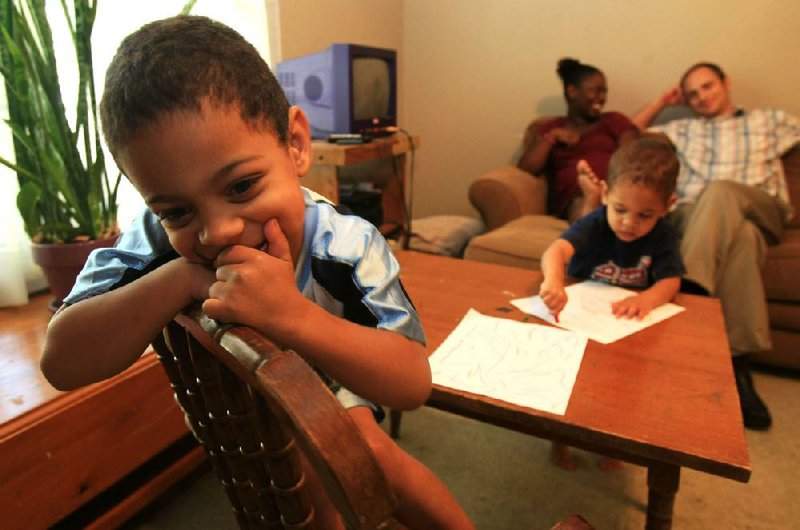 Samuel Duncan (left), 4, plays at home Wednesday with brother Benjamin, 2. Parents Jessi and Braden Duncan (background) thought they had Samuel’s school picked out until their faith complicated their plans. 