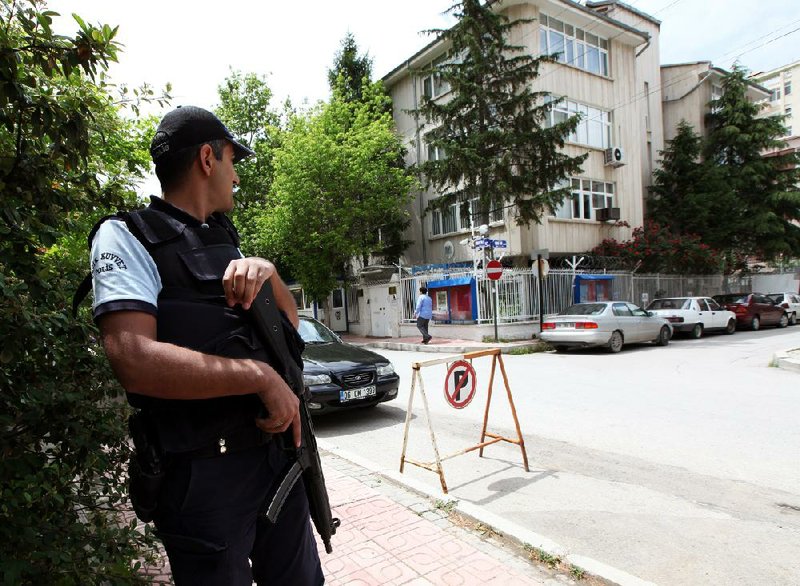 A Turkish riot police officer patrols outside the Syrian embassy. seen at centre, in Ankara. Turkey, Wednesday, May 30, 2012. Turkey decided to expel Syria's Charge d'Affaires and other diplomats in Ankara within 72 hours.