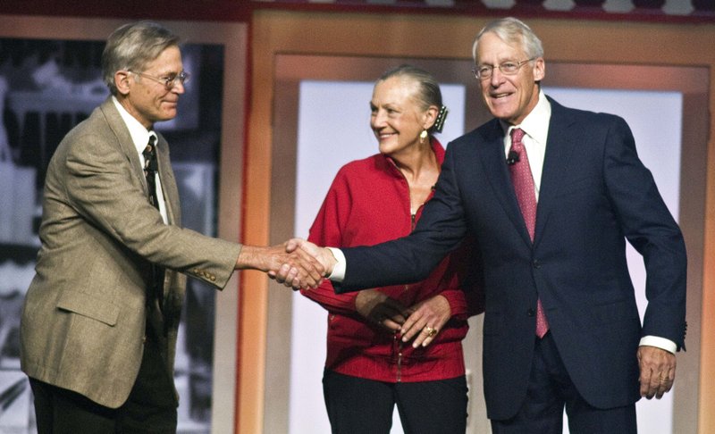Jim Walton, left, Alice Walton, center, and Robson Walton, right, greet each other during the beginning of the Walmart Stores Inc. shareholders' meeting in Fayetteville, Ark., Friday, June 1, 2012. The three siblings are the children of the late Sam Walton, founder of Walmart. 
