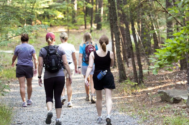 Striding downhill toward the Rocky Valley Trail trailhead, participants in Pinnacle Mountain State Park’s weekly Wild Women Wednesdays carry their own water but otherwise have lots of group support. The outings are designed to help women get to know park trails and meet new friends. 