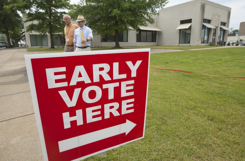 FILE — Two men walk from a polling place in Little Rock, Ark., Monday, May 7, 2012, the first day of early voting ahead of the May 22 primary and non-partisan judicial election.