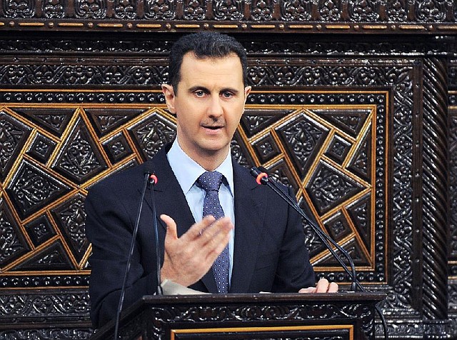 In this photo released by the Syrian official news agency SANA, shows Syrian President Bashar Assad, as he delivers a speech at the parliament in Damascus, Syria, Sunday, June 3, 2012. The president's first comments on the massacre expressed horror over the deaths of more than 100 people, nearly half of them children. U.N. investigators say there are strong suspicions that pro-government gunmen carried out the killings, but Assad denied that. (AP Photo/SANA)