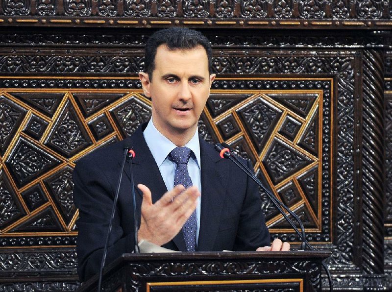 In this photo released by the Syrian official news agency SANA, shows Syrian President Bashar Assad, as he delivers a speech at the parliament in Damascus, Syria, Sunday, June 3, 2012. The president's first comments on the massacre expressed horror over the deaths of more than 100 people, nearly half of them children. U.N. investigators say there are strong suspicions that pro-government gunmen carried out the killings, but Assad denied that. (AP Photo/SANA)