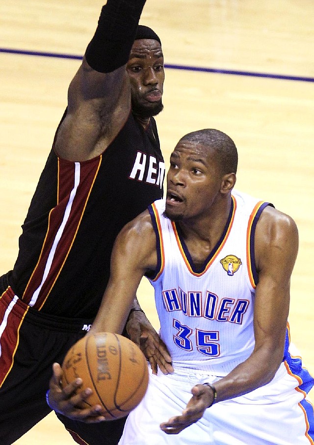 Oklahoma City Thunder forward Kevin Durant (35) tries to shoot around Miami Heat forward LeBron James during the second half of Thursday’s Game 2 of the NBA Finals in Oklahoma City.The two star forwards have been making the series interesting for fans. 