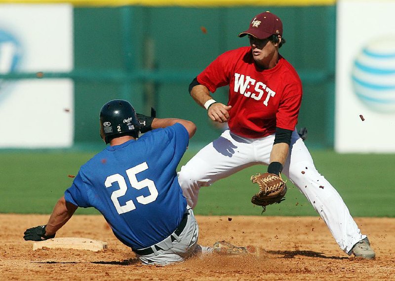 East All-Star Parker Parrish of Clinton slides safely into second base Monday as West shortstop Levi Runyan of Lake Hamilton tries to field the throw during the East team’s 4-1 victory in the opening game of the Arkansas High School Coaches Association All-Star baseball game at Baum Stadium in Fayetteville. 