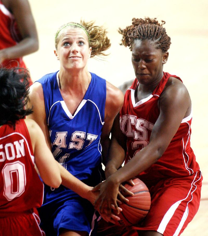 
Dulincia Keener of Texarkana (right) tries to strip the ball from Melissa Wolff of Cabot during the All-Star girls basketball game in Bud Walton Arena in Fayetteville on Wednesday, June 20, 2012.