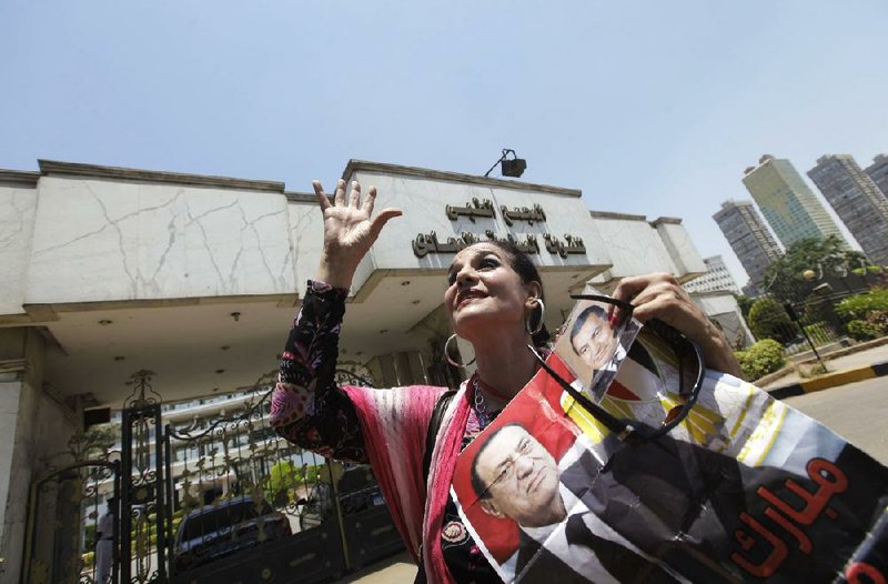 An Egyptian woman holds posters of ousted President Hosni Mubarak on Wednesday outside the military hospital in Cairo where Mubarak is being treated. 