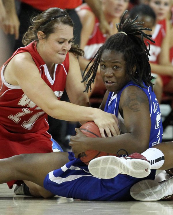 Breanna Jones, left, of Farmington tries to wrestle the ball from Sandy Jackson of North Little Rock on Wednesday at Bud Walton Arena for the Arkansas High School Coaches Association All Star girls basketball game.
