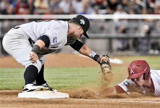 South Carolina first baseman Christian Walker, left, picks off Arkansas' Matt Vinson during a double play in the sixth inning of an NCAA College World Series baseball game in Omaha, Neb., Thursday, June 21, 2012. Arkansas' Jake Wise was out at second base on the play. (AP Photo/Ted Kirk)