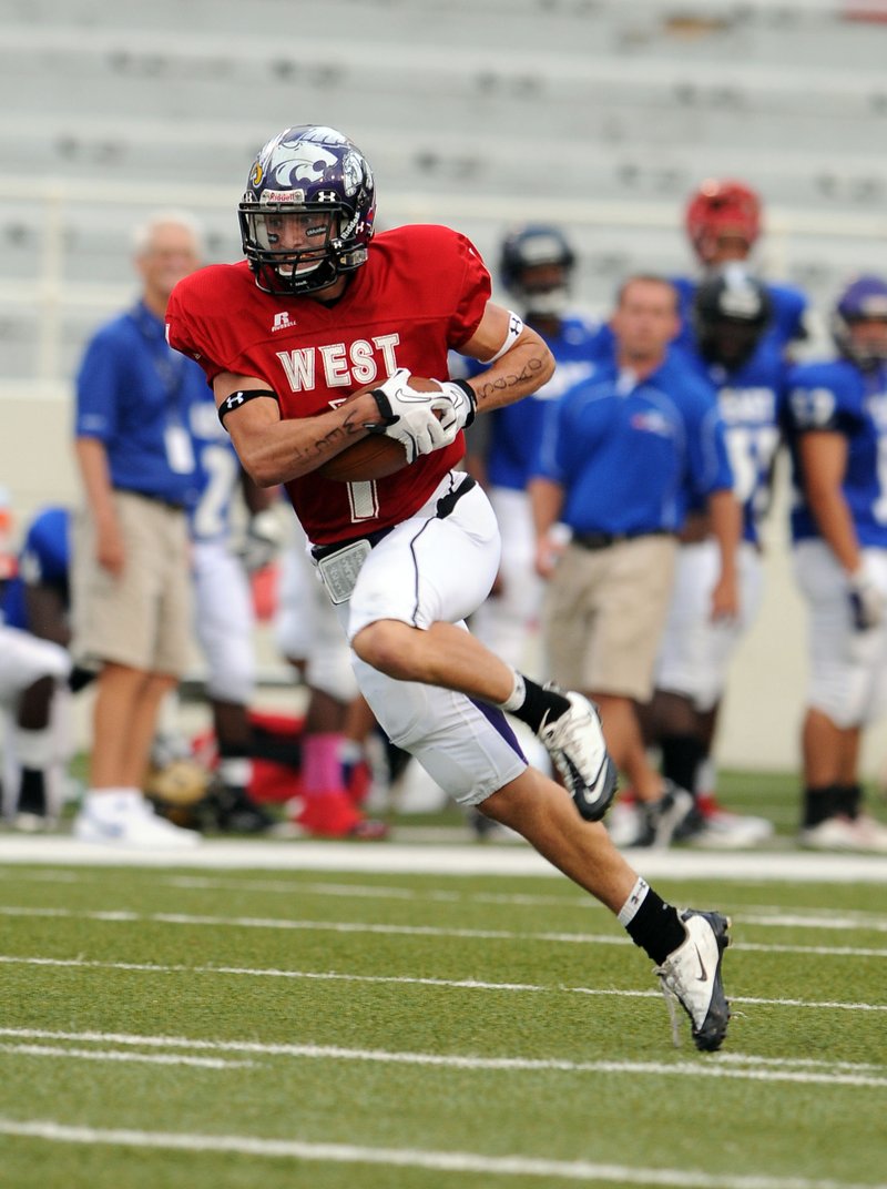 Brad Culp of Fayetteville turns with the ball after a catch that leads to a first quarter touchdown against the East in the All-Star game Thursday at Razorback Stadium in Fayetteville. 