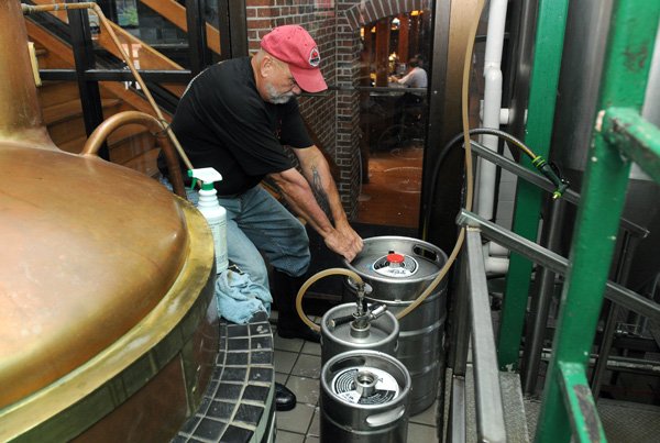 Kit Core of Core Brewing and Distilling Company moves a keg of beer after filling it up at Hog Haus Brewing Company, located in Fayetteville. Hog Haus’ brewing operations are currently maintained by Core Brewing and Distilling, which is constructing a commercial brewery in Springdale. 