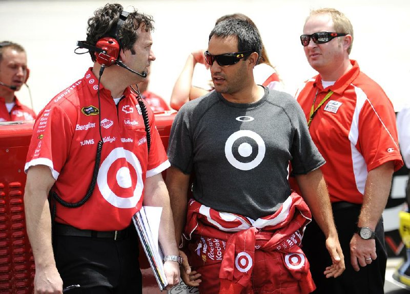 Sprint Cup Series driver Juan Pablo Montoya, right, talks to his crew during qualifying for the FedEx 400 benefiting Autism Speaks NASCAR Sprint Cup Series auto race, Saturday, June 2, 2012, in Dover, Del. (AP Photo/Nick Wass)