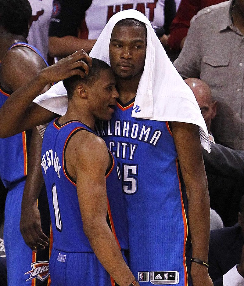 Oklahoma City Thunder small forward Kevin Durant and point guard Russell Westbrook (0) watch the final moments of Game 5 of the NBA finals basketball series against the Miami Heat, Thursday, June 21, 2012, in Miami. The Heat won 121-106 to become the 2012 NBA Champions. (AP Photo/Wilfredo Lee)