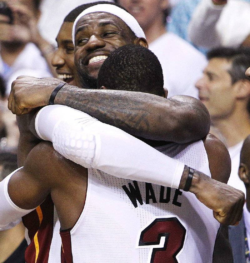 Miami Heat small forward LeBron James (6) and shooting guard Dwyane Wade react in the final moments during the second half at  Game 5 of the NBA finals basketball series against the Oklahoma City Thunder, Thursday, June 21, 2012, in Miami. The Heat won 121-106 to become the 2012 NBA Champions. (AP Photo/Lynne Sladky)