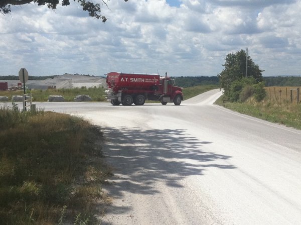 A large truck leaves Northwest Arkansas Quarries on Washington County 91 and drives over a white, chalky substance. Nearby residents said the substance travels by air and coats their property. They plan to appeal a recent permit approved by the county Planning Board to expand stockpile areas within the quarry. 