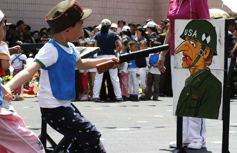 A pupil at the Kyongsang Kindergarten in Pyongyang, North Korea, takes aim at a depiction of a U.S. soldier during an International Children’s Day celebration June 1. 