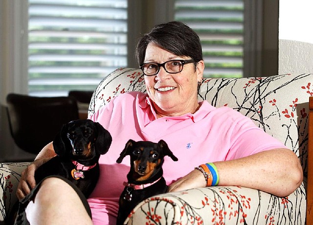 Donna Meigs, who was diagnosed with Huntington’s disease last year, relaxes Wednesday in her Fayetteville home with her dachshunds, Alley (left) and Lydia. Meigs is among those promoting a new Huntington’s support group in Fayetteville.