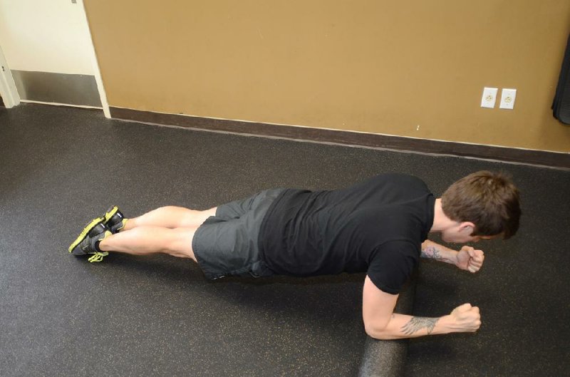 Joey Edwards has to clench his core to maintain form while he rocks his ankles forward and back and his elbows make the foam cylinder roll in the Foam Roller Plank. 