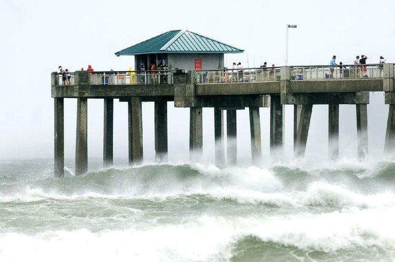 Waves crash against the Okaloosa Island Fishing Pier in Fort Walton Beach, Fla., as Tropical Storm Debby pounded the Gulf Coast on Sunday, leaving one dead.