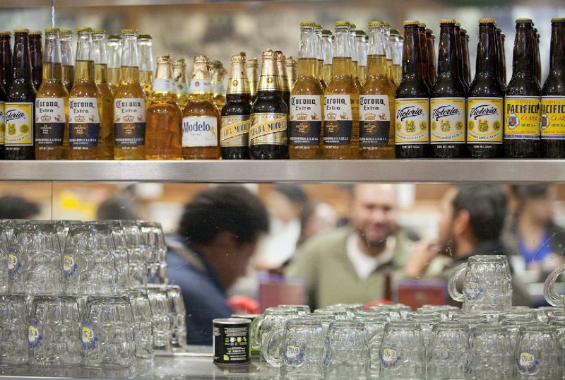 A selection of Grupo Modelo SAB brand beers sits on a shelf at a brew pub in Mexico City in this file photo. Anheuser-Busch InBev NV and Grupo Modelo confirmed Monday that the companies are negotiating InBev’s bid to buy the half of Modelo that it doesn’t already own. 