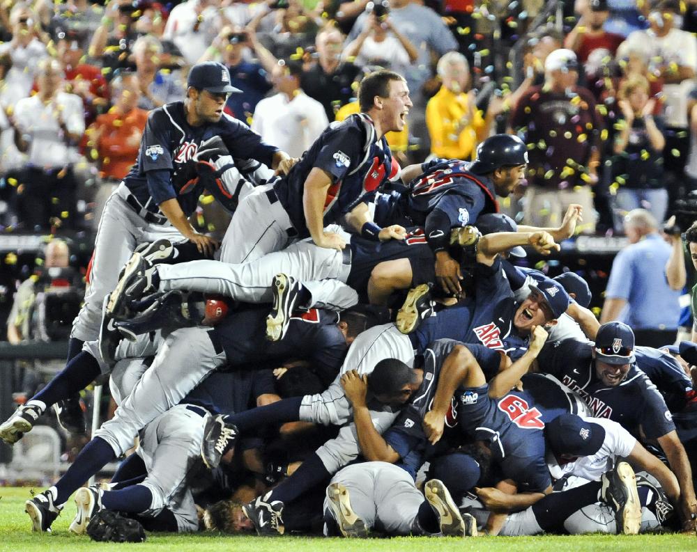 Arizona players pile up following their 4-1 victory over South Carolina in Game 2 to win the NCAA College World Series baseball finals in Omaha, Neb., Monday, June 25, 2012. (AP Photo/Dave Weaver)