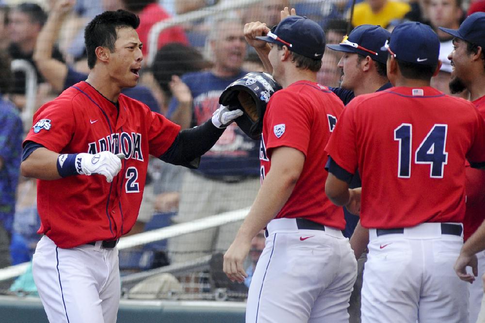 Arizona's Robert Refsnyder, left, celebrates at the dugout with teammates after he hit a two-run home run against South Carolina in the first inning of Game 1 of the NCAA College World Series baseball finals in Omaha, Neb., Sunday, June 24, 2012. (AP Photo/Eric Francis)