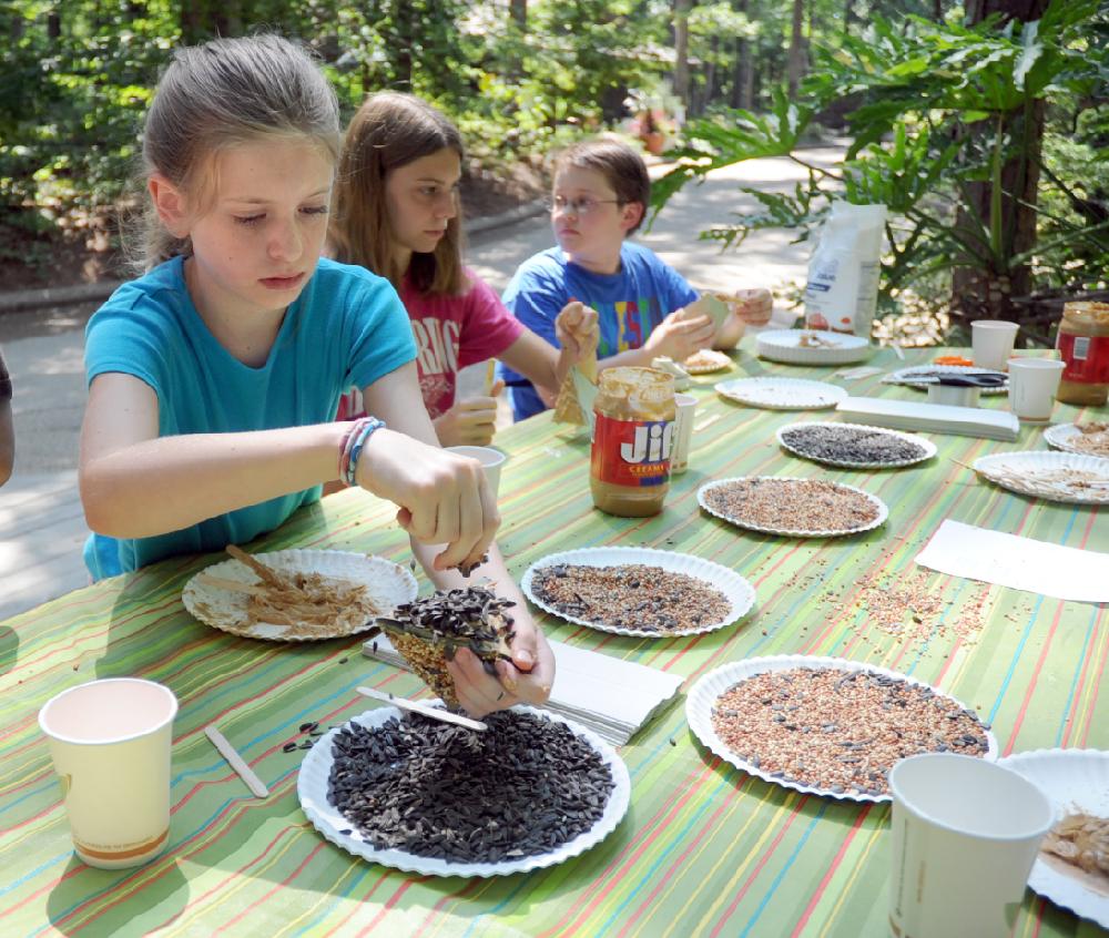 Colleen Miller, 9, left, Aubrey Miller, 14, both of Hot Springs, and Dawson Mowry, 11, of Sheridan, make edible bird house at Garvan Woodland Gardens on Monday, June 25, 2012. Part of the children's series, they learned about birds and made three houses filled with different things for the birds to snack on. (The Sentinel-Record/Mara Kuhn)