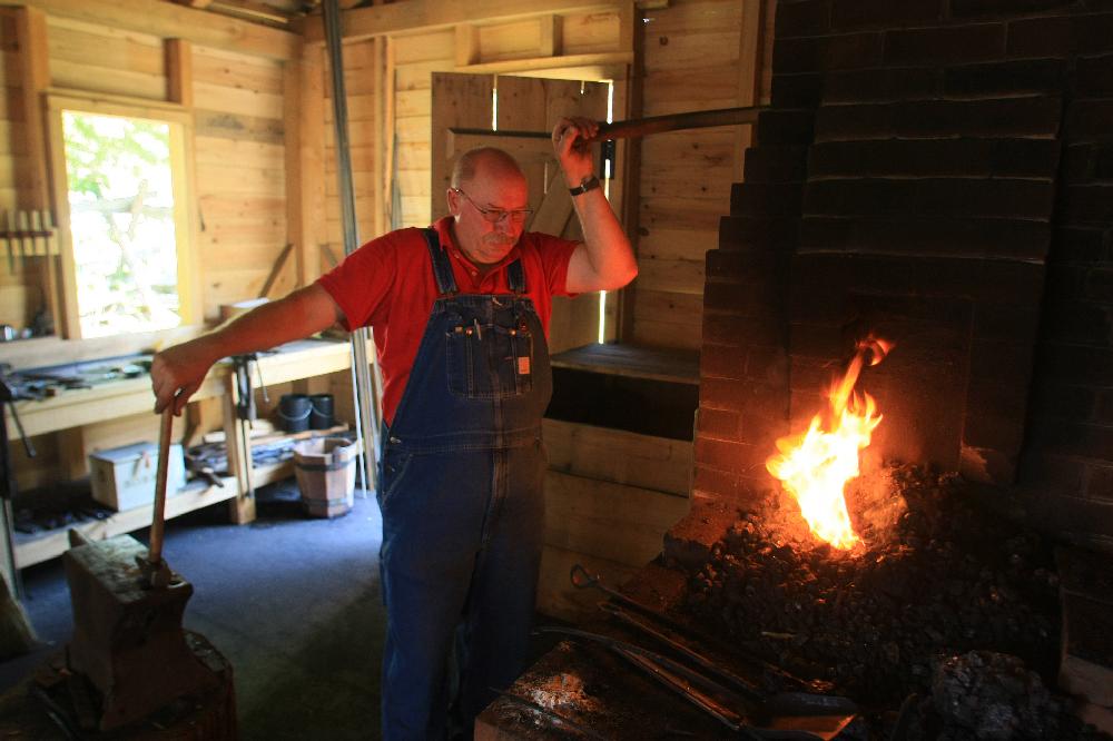 Arkansas Democrat-Gazette/RICK MCFARLAND --06/25/12-- Lin Rhea, a Master Smith, fires the forge in the blacksmith shop at the Historic Arkansas Museum in Little Rock Monday.He was preparing for a demonstration on forging techniques.