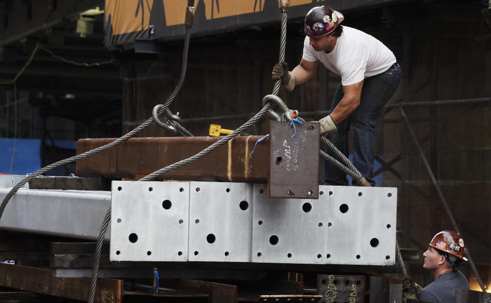 Ironworkers slip steel cables around a load of steel before it is hoisted to the top of Four World Trade Center, Monday, June 25, 2012. The 72-floor, 977-foot tower is scheduled to open late next year. It's expected to be the first tower completed on the 16-acre site since the 9/11 attacks. (AP Photo/Mark Lennihan)
