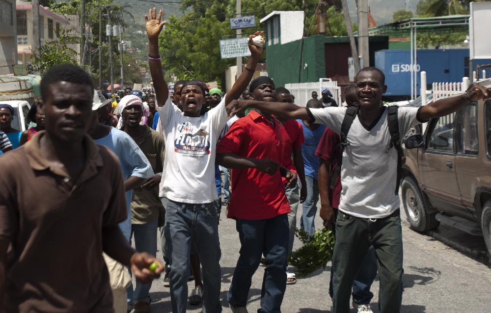 Haitians protest, chanting slogans against a government plan to destroy hillside shanties for a flood-control project, in Port-au-Prince, Haiti, Monday, June 25, 2012. More than 1,000 demonstrators marched, some chanting threats to burn down the relatively affluent district if the authorities flatten their homes. Many of the threatened homes are in Jalousie, a cinderblock shantytown that spreads across a mountainside alongside the relatively affluent city of Petionville that makes up the Port-au-Prince metro area. (AP Photo/Dieu Nalio Chery)
