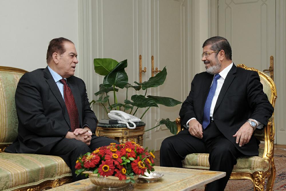 In this photo released by Middle East News Agency, the Egyptian official news agency, caretaker Prime Minister Kamal el-Ganzoury, left, meets with newly elected President Mohammed Morsi in Cairo, Egypt, Monday, June 25, 2012. Morsi met with the military-backed Prime Minister el-Ganzouri, who resigned Monday and was asked to head a caretaker government until Morsi nominates a new one. (AP Photo/Middle East News Agency, HO)