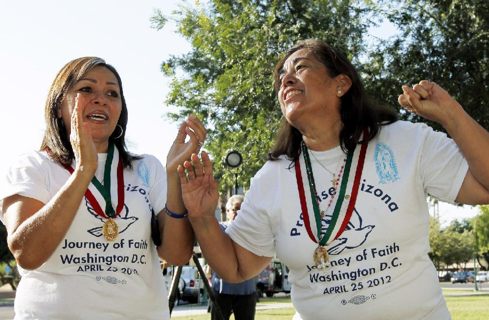 Rosa Maria Soto, right, and Maria Durand, both from Arizona, cheer as they react to the United States Supreme Court decision regarding Arizona's controversial immigration law, SB1070, comes down at the Arizona Capitol Monday, June 25, 2012, in Phoenix. The Supreme Court struck down key provisions of Arizonas crackdown on immigrants Monday but said a much-debated portion on checking suspects status could go forward. (AP Photo/Ross D. Franklin)