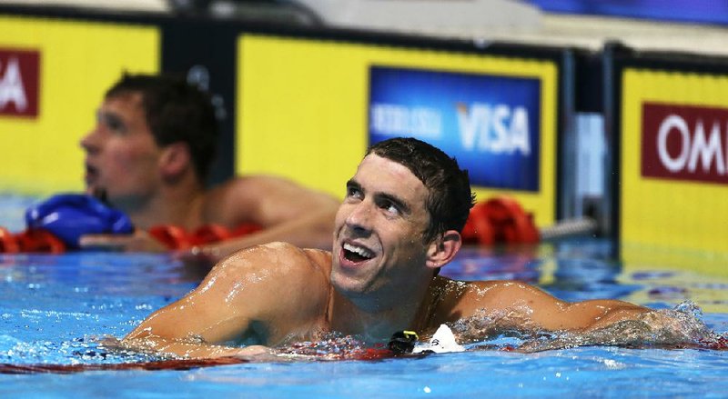 Michael Phelps smiles after winning the men's 200-meter freestyle final at the U.S. Olympic swimming trials on Wednesday, June 27, 2012, in Omaha, Neb. At left is Ryan Lochte. (AP Photo/Mark Humphrey)