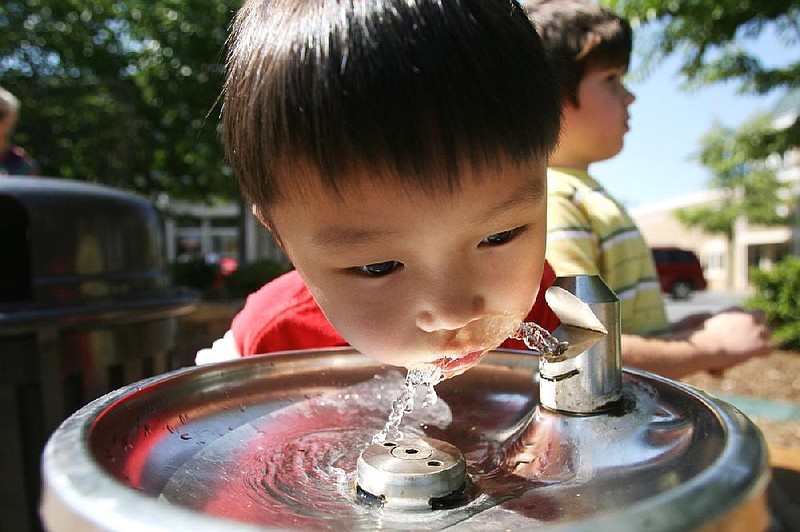 Arkansas Democrat-Gazette/RYAN MCGEENEY --06-28-2012-- Albert Liu of Fayetteville, 6, gets a sip of water Thursday morning while experiencing the  Fayetteville Farmers' Market with a group of several other area school-aged children. The group was participating in the Farm-to-School summer lunch program, which involves local farmers and producers in efforts to feed school-aged children.