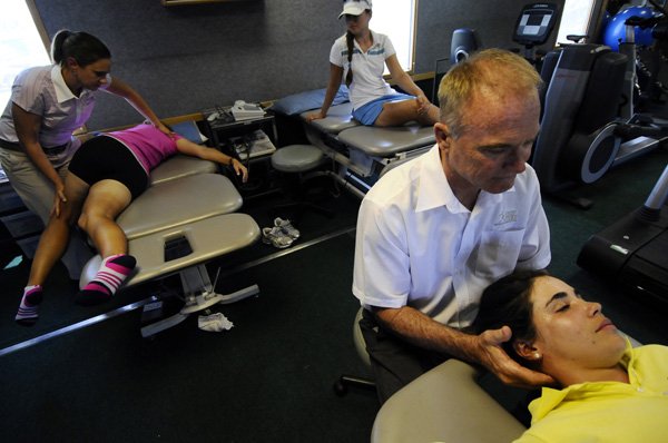 Golfers Maria Hernandez, right, and Elisa Serramia, left, both of Spain are treated Thursday by physical therapists Bob Mottram and Caroline Nichols, respectively, as Victoria Tanco of Argentina waits her turn in the mobile LPGA Sports Medicine Center at Pinnacle Country Club in Rogers. 