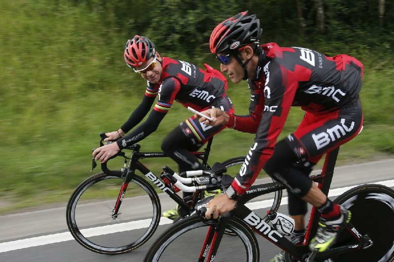 American cyclist George Hincapie (right) uses his phone to take pictures of defending Tour de France champion Cadel Evans of Australia during Friday’s training run near Liege, Belgium. The Tour de France begins today with a 6.4-kilometer prologue that starts and finishes in Liege. 