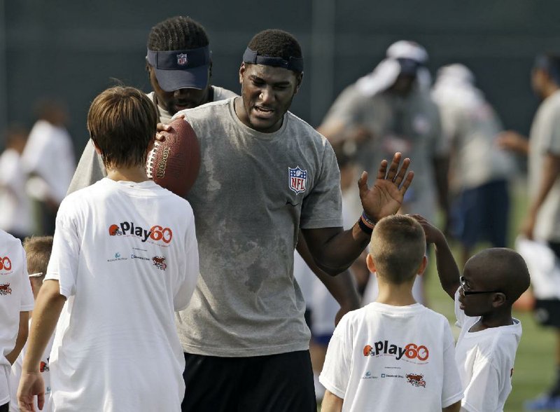 Jacksonville Jaguars rookie wide receiver Justin Blackmon greets kids at an NFL football Play 60 youth clinic at the Cleveland Browns training facility in Berea, Ohio Friday, June 29, 2012. (AP Photo/Mark Duncan)