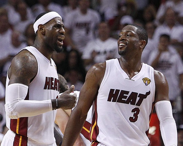 Miami Heat small forward LeBron James (6) and shooting guard Dwyane Wade (3) react against the Oklahoma City Thunder during the second half at  Game 5 of the NBA finals basketball series, Thursday, June 21, 2012, in Miami. The Heat won 121-106 to become the 2012 NBA Champions. (AP Photo/Lynne Sladky)