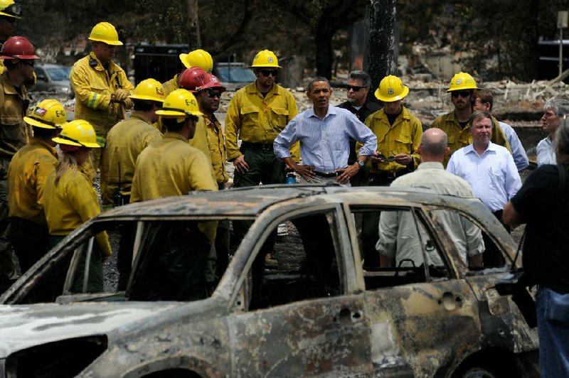 President Barack Obama talks with firefighters Friday as he tours the Mountain Shadow neighborhood devastated by wildfires in Colorado Springs, Colo. 