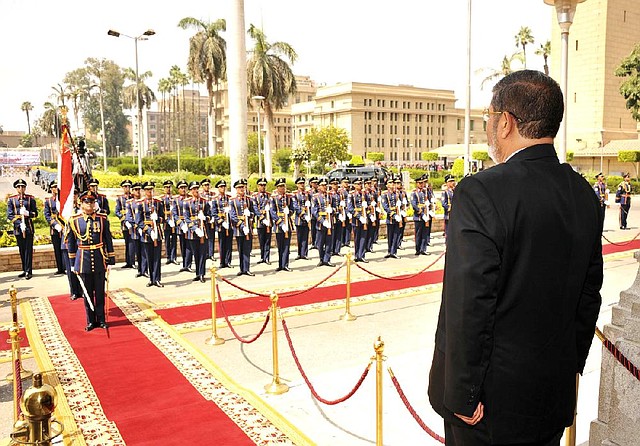 In this image released by the Egyptian Presidency, Egyptian President Mohammed Morsi stands before a military honor guard after his inauguration in Cairo, Egypt, Saturday, June 30, 2012. Islamist Mohammed Morsi promised a "new Egypt" and unwavering support to the powerful military as he took the oath of office Saturday to become the country's first freely elected president, succeeding Hosni Mubarak who was ousted 16 months ago. (AP Photo/Ahmed Fouad, Egyptian Presidency)