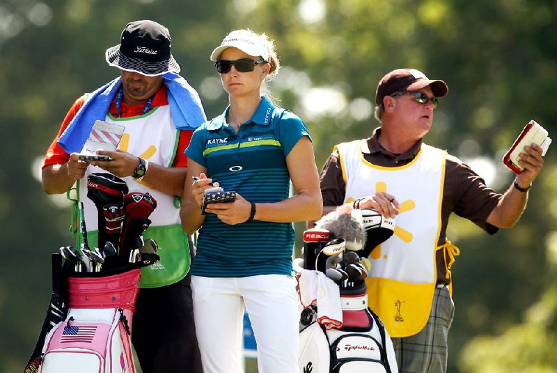 Ryann O’Toole (center), waiting with two of her group’s caddies on the third tee during the second round of the NW Arkansas Championship at Pinnacle Country Club in Rogers on Saturday, says she uses electrolyte pills to help her stay hydrated. O’Toole shot a 68 and is in a four-way tie for third. 