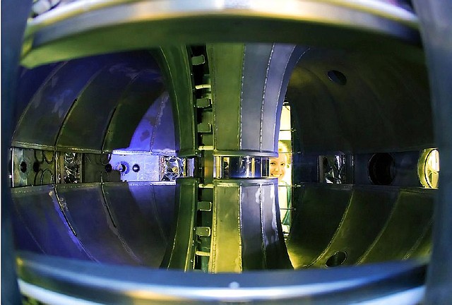 A worker at the Princeton Plasma Physics Laboratory peers into a device being used to develop nuclear fusion, a potential source of clean energy. 