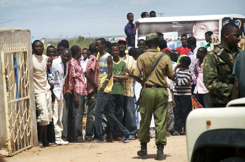 Members of the Kenyan security forces keep onlookers back from the African Inland Church in Garissa, Kenya, on Sunday after a deadly attack. 