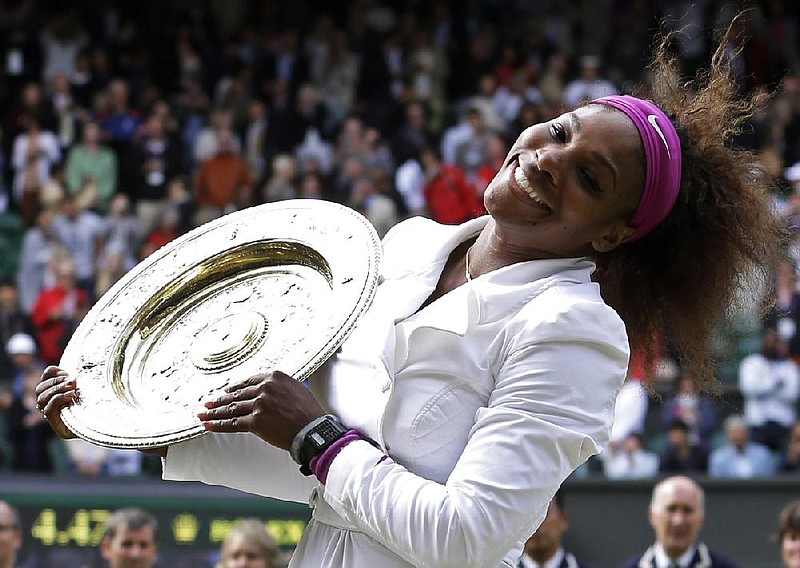 Serena Williams of the United States poses with her trophy after defeating Agnieszka Radwanska of Poland to win the women's final match at the All England Lawn Tennis Championships at Wimbledon, England, Saturday, July 7, 2012. (AP Photo/Kirsty Wigglesworth)