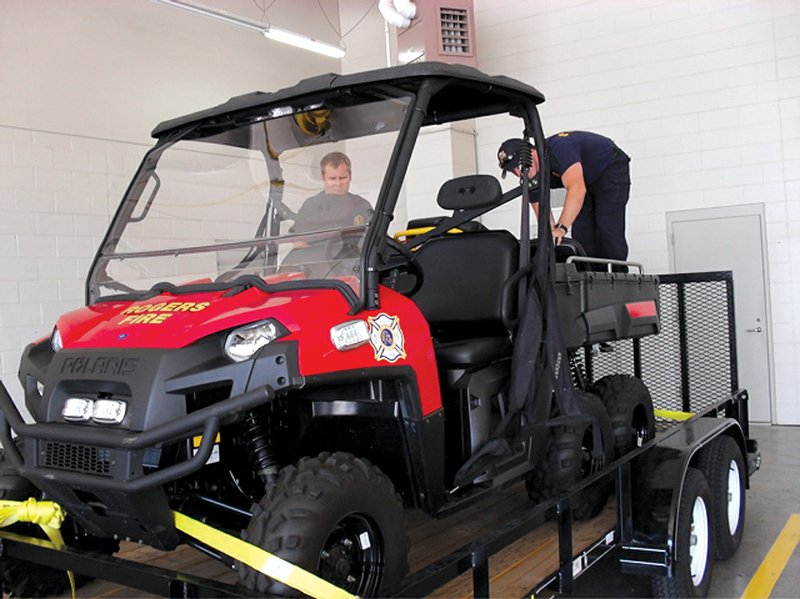 Rogers firefighters Derek Reaves, left, and Ramsey Emerson work on the fire department’s Polaris six-wheeler, which is used to respond to fire and emergency situations on the city’s trail system or in crowded areas.