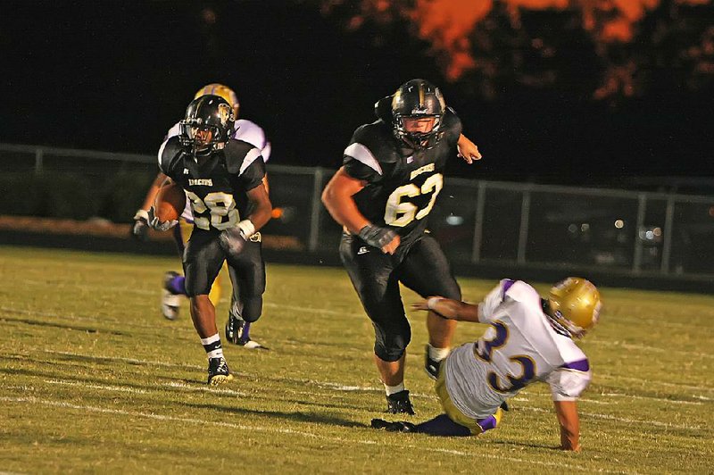 Jeremy Ward (63) delivers a lead block in front of running back Quillen Porter while playing for Pottsville last year. Ward, who will be a freshman offensive lineman for Arkansas this fall and said he grew up a Razorbacks fan, never wavered on his commitment to the Razorbacks, despite receiving scholarship offers from several other schools, including Alabama, LSU, Ole Miss, Oklahoma State and Arkansas State. 