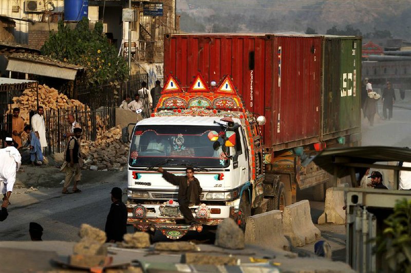 A man sits on a NATO supply truck entering Afghanistan from Pakistan at Torkham border crossing east of Kabul, Afghanistan, on July 12, 2012. 