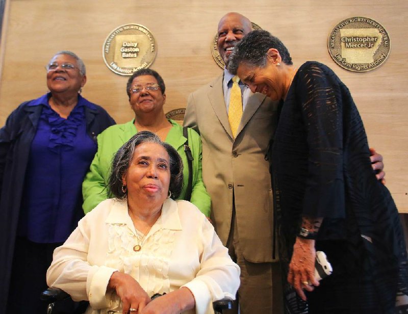 Five members of the Little Rock Nine pose with plaques bearing their names to be placed in the River Market District. Minnijean Brown (from left, standing), Elizabeth Eckford, Terrence Roberts, Carlotta Walls LaNier and Thelma Mothershed Wair (seated) attended a civil-rights heritage commemoration Saturday at the Clinton Presidential Center. 