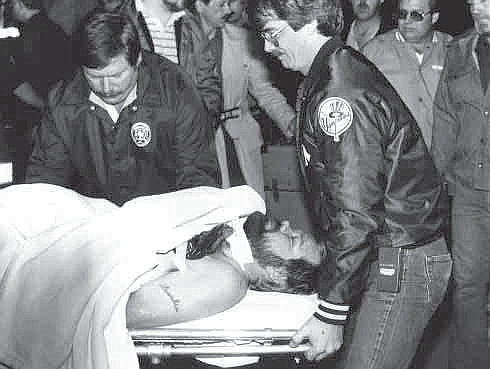 Frankie Parker is carried away from the Rogers Police Department after he was wounded during an armed standoff
on Nov. 5, 1984. Also pictured are the late Richard Feast, left, and Rick Williams. Parker killed his in-laws, James and
Sandra Warren, and wounded Rogers police officer Ray Feyen, and his estranged wife, Pam Warren.