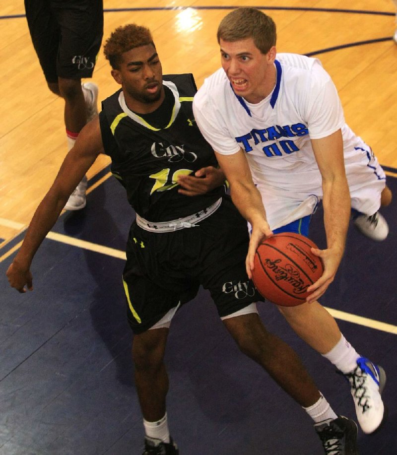 Texas Titans player Mickey Mitchell (right) drives to the basket past The City’s Joshua Wallace during Sunday’s championship game at the AAU 15-Under National Championship at Pulaski Academy in Little Rock. The City, based in New York, never trailed and won 32-30. Michael Williams led The City with 12 points. 